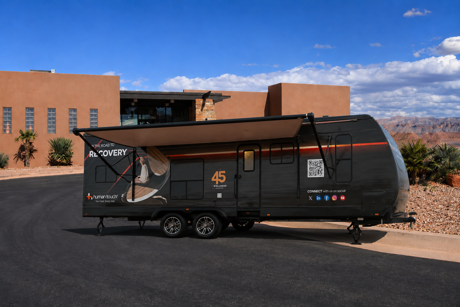 The Recovery Lounge trailer parked outside a desert clubhouse with the awning extended
